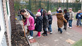 Met  hulp van omgekeerde bezemsteel  gaan de bloembollen op het schoolplein de grond in